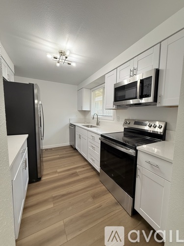 A kitchen with white cabinets and stainless steel appliances.