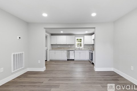 A spacious kitchen with white cabinets and a large island.