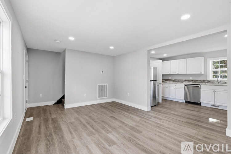 A spacious kitchen with white cabinets and a dining area.