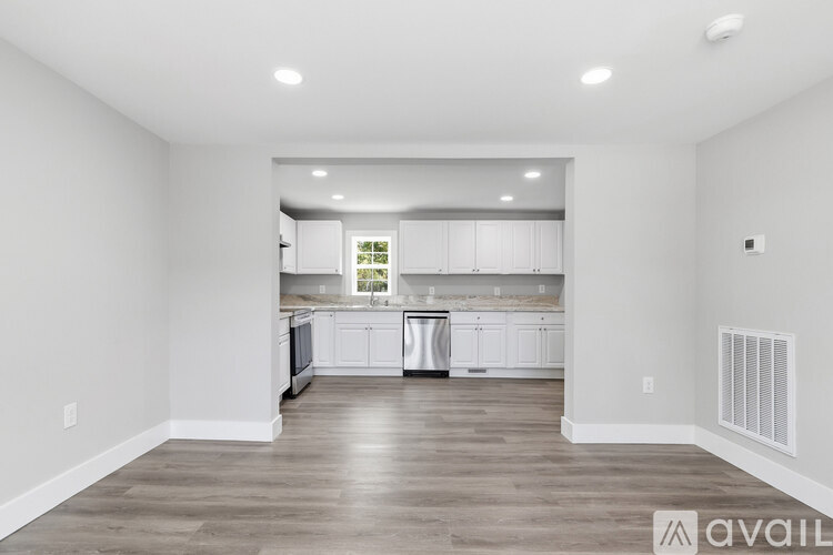 A spacious kitchen with white cabinets and a large island.