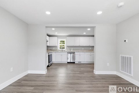 A spacious kitchen with white cabinets and a large island.