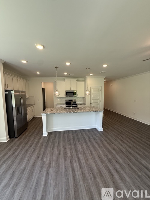 A kitchen with a granite countertop and a refrigerator.