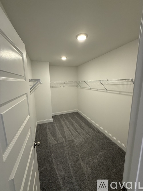 A hallway with a carpeted floor and white walls.