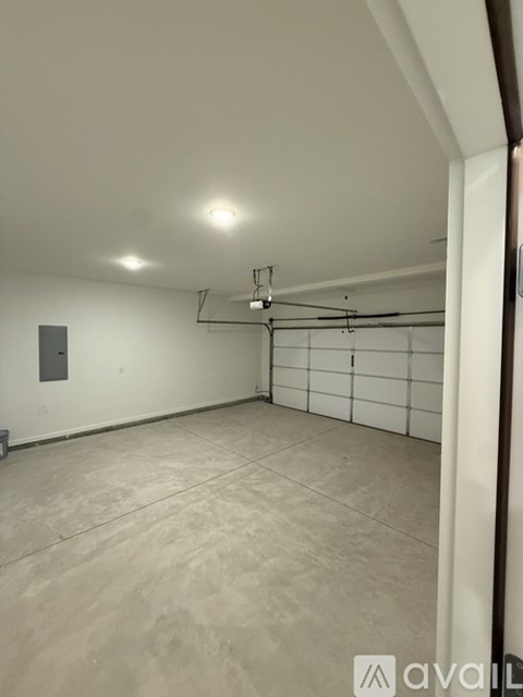 A spacious room with a tiled floor and a white wall.