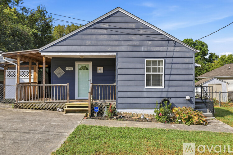A blue house with a green door and a porch.