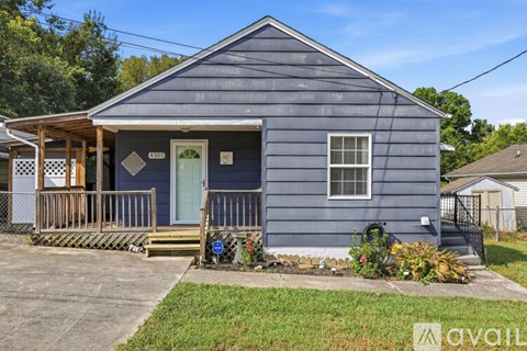 A blue house with a green door and a porch.