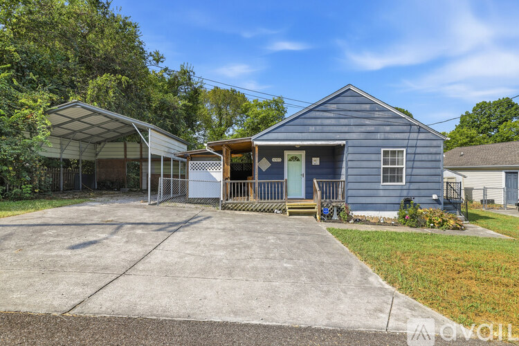 A blue house with a white garage door and a covered patio.