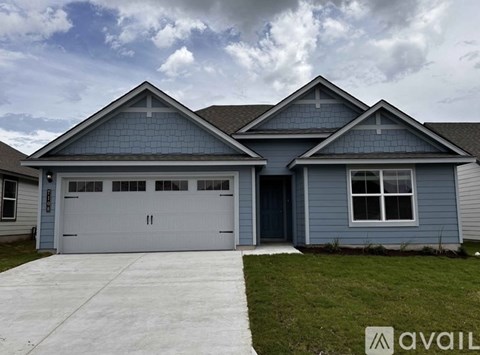 A two-story house with a garage and a driveway.