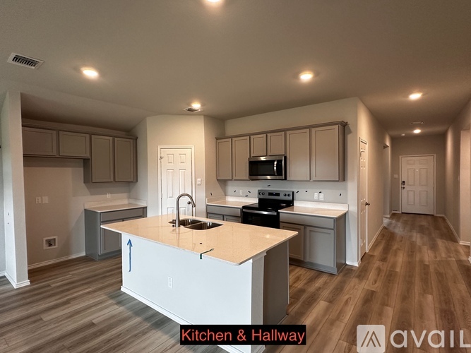 A kitchen and hallway with wood flooring and white walls.