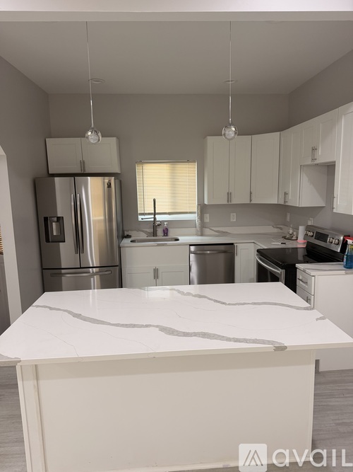 A kitchen with a white countertop and cabinets.