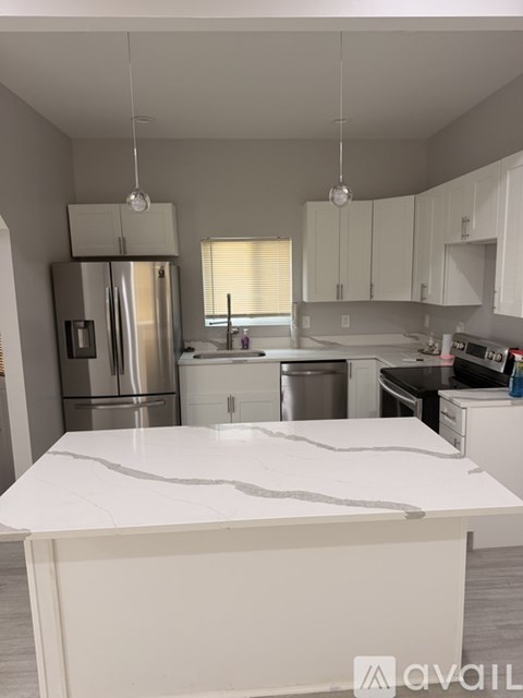 A kitchen with a white countertop and cabinets.