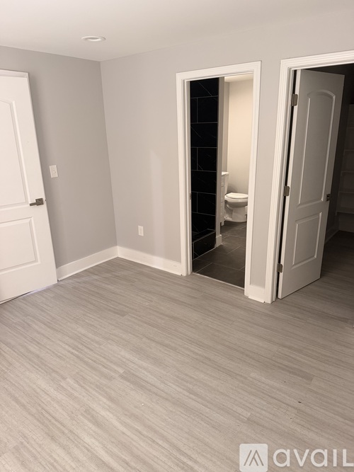 A room with a toilet visible through an open door.