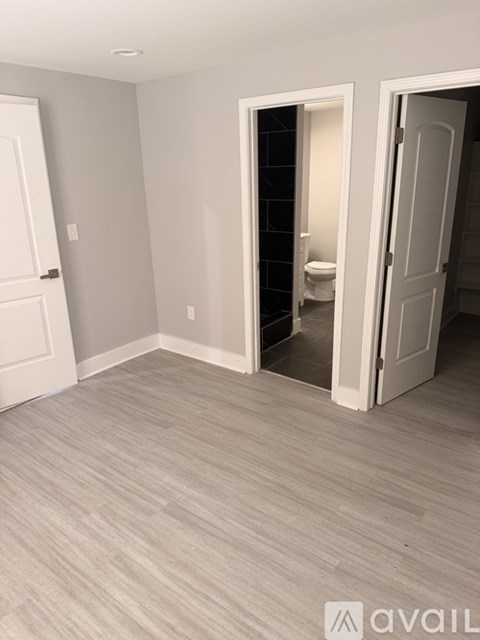 A room with a toilet visible through an open door.