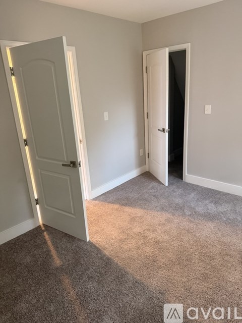 A room with two doors, one open and one closed.