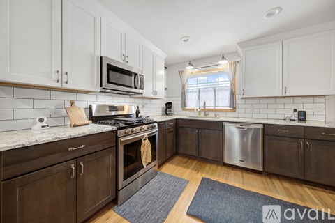 A kitchen with wooden cabinets and a stainless steel dishwasher.