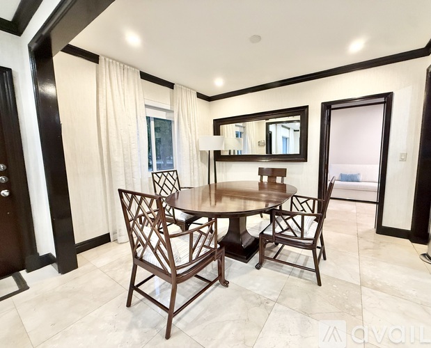 A dining room with a round table and chairs.