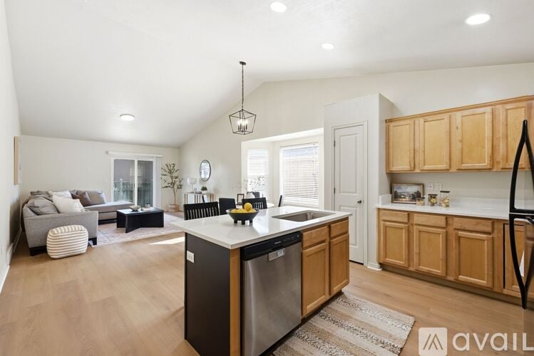 A kitchen with wooden cabinets and a black dishwasher.