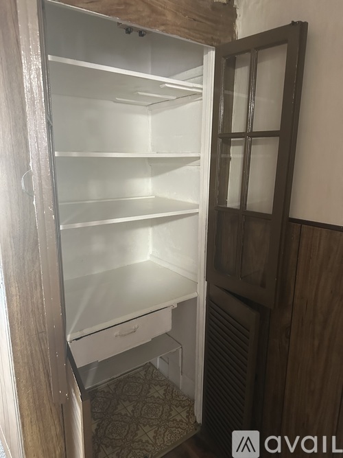A white refrigerator with the door open in a room.