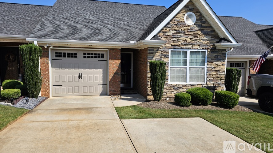 A house with a stone facade and a grey garage door.