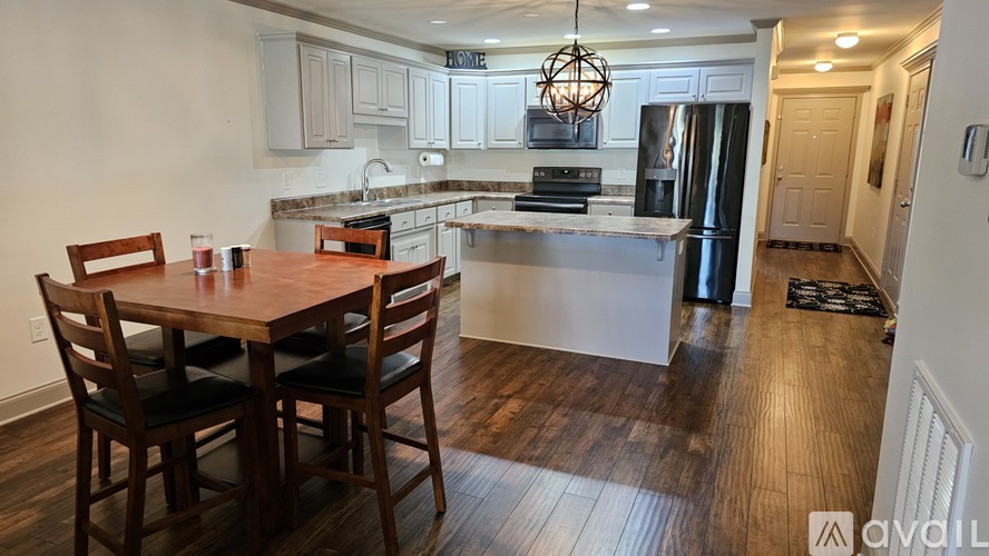 A kitchen with a dining table and chairs is available for rent.