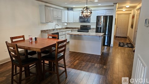 A kitchen with a dining table and chairs is available for rent.