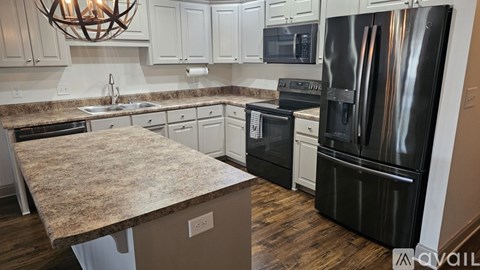 A kitchen with a granite countertop and stainless steel appliances.