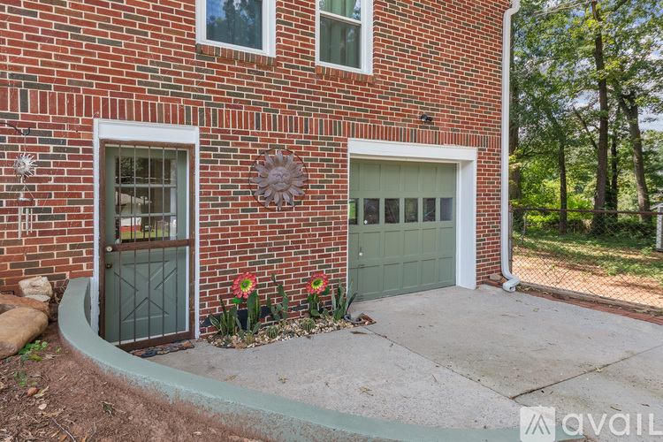 A red brick house with a green garage door and a white door.