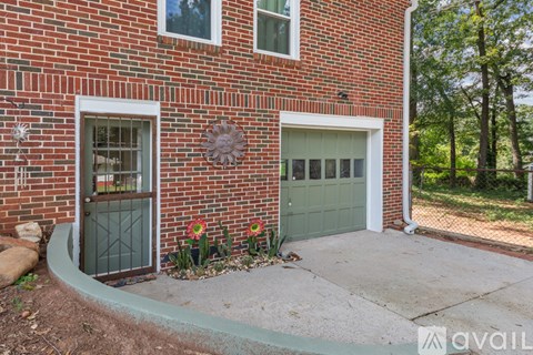 A red brick house with a green garage door and a white door.