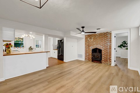 A living room with a fireplace and a ceiling fan.