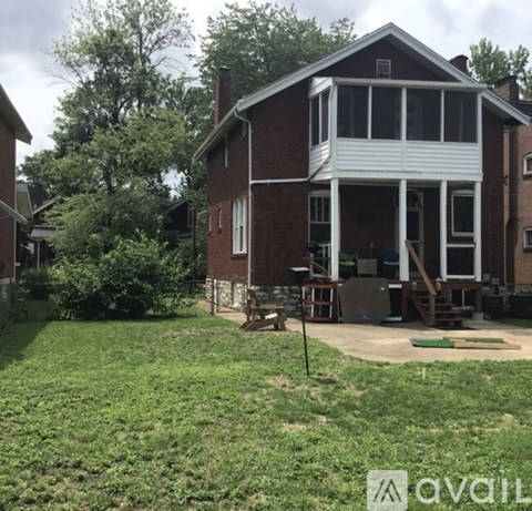 A house with a white porch and a green lawn in front.