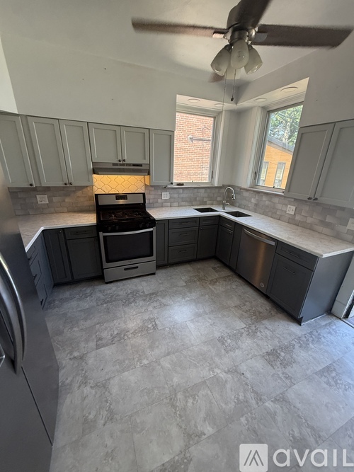 A kitchen with a tile floor and a ceiling fan.