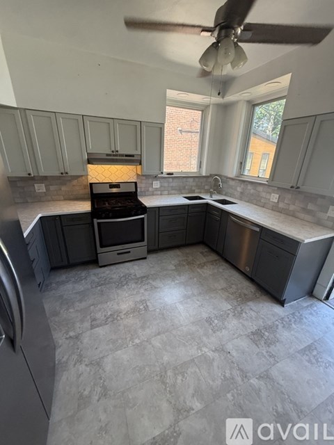 A kitchen with a tile floor and a ceiling fan.