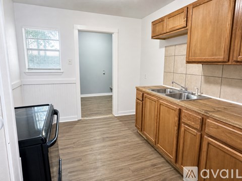A kitchen with wooden cabinets and a black fridge.
