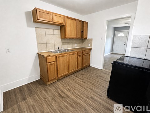 A kitchen with wooden cabinets and a black appliance.