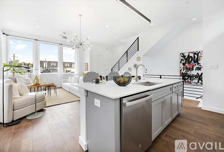 A modern kitchen with a white countertop and stainless steel appliances.