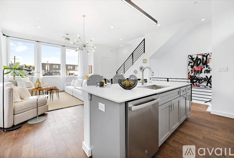 A modern kitchen with a white countertop and stainless steel appliances.