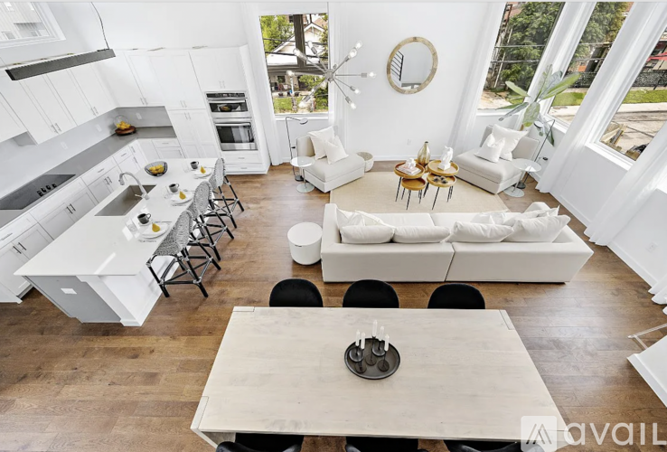 A modern kitchen with white cabinets and a wooden table.