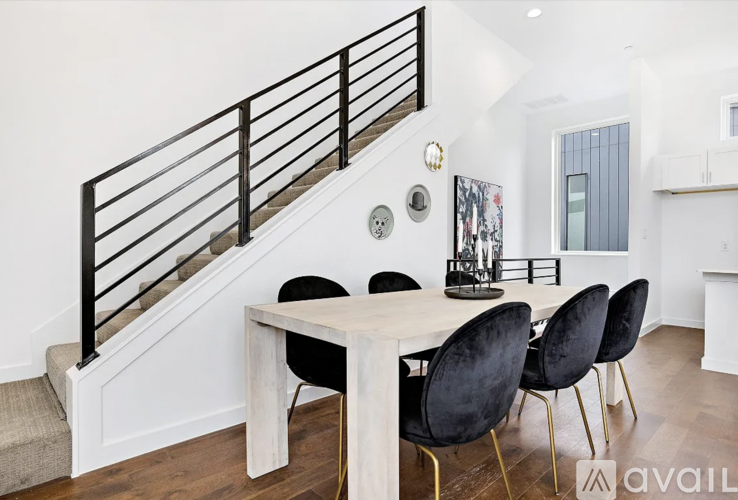 A dining room with a white table and black chairs.