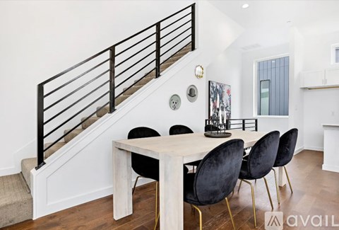 A dining room with a white table and black chairs.