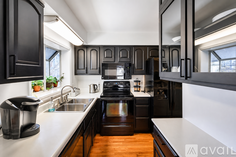 A modern kitchen with dark wood cabinets and stainless steel appliances.