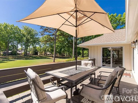 A patio with a table and chairs under an umbrella.