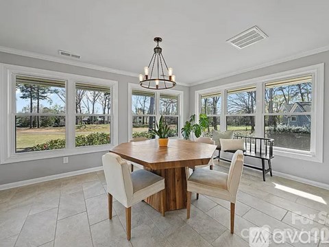 A dining room with a wooden table and chairs.