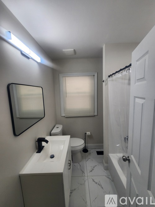 A bathroom with a sink, toilet, and a mirror.
