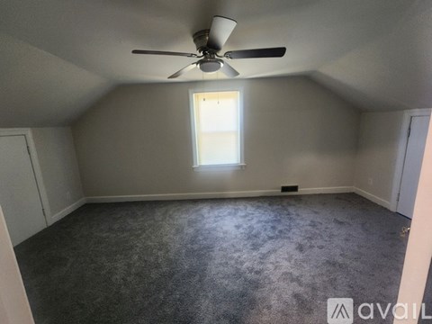 A room with a ceiling fan and a window.