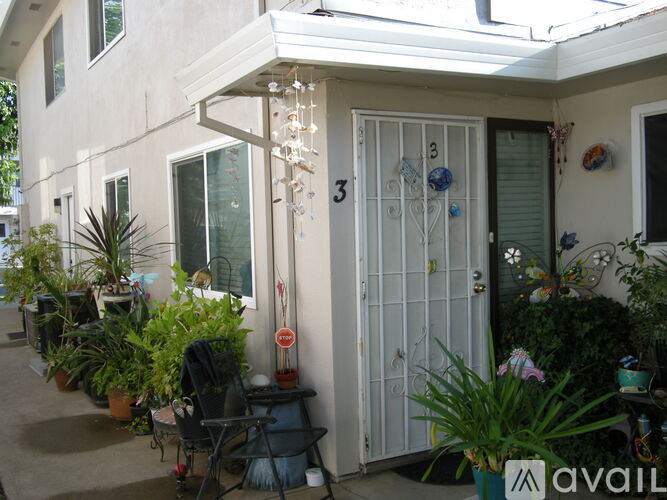 A patio with a table and chairs and a white door with a number 3 on it.