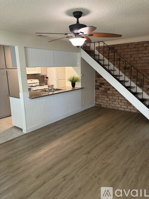 A room with a ceiling fan and wooden flooring.