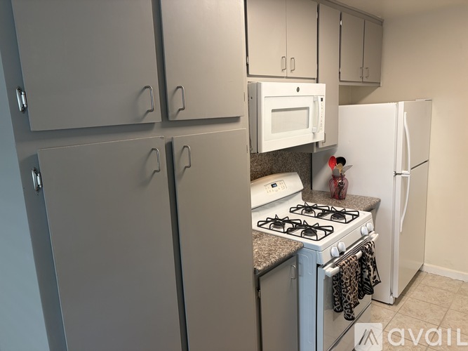 A kitchen with a white fridge, white microwave, and a white stove.