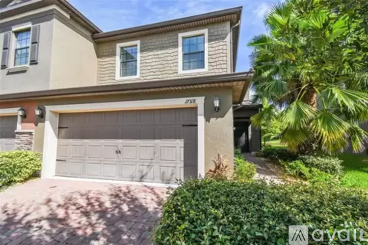 A two-story house with a garage and a driveway.