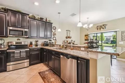 A kitchen with dark brown cabinets and stainless steel appliances.