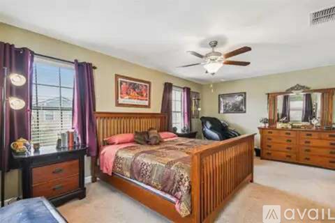 A bedroom with a bed, dresser, and mirror.